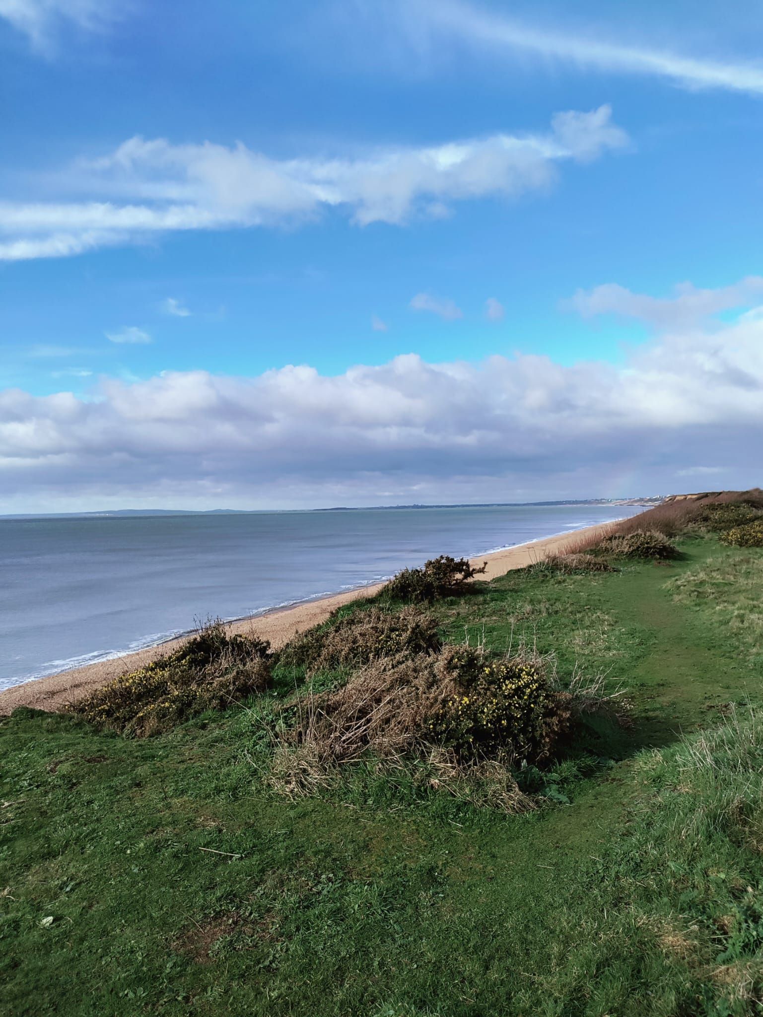 Wide Hampshire coastline with open skies and a peaceful shoreline path